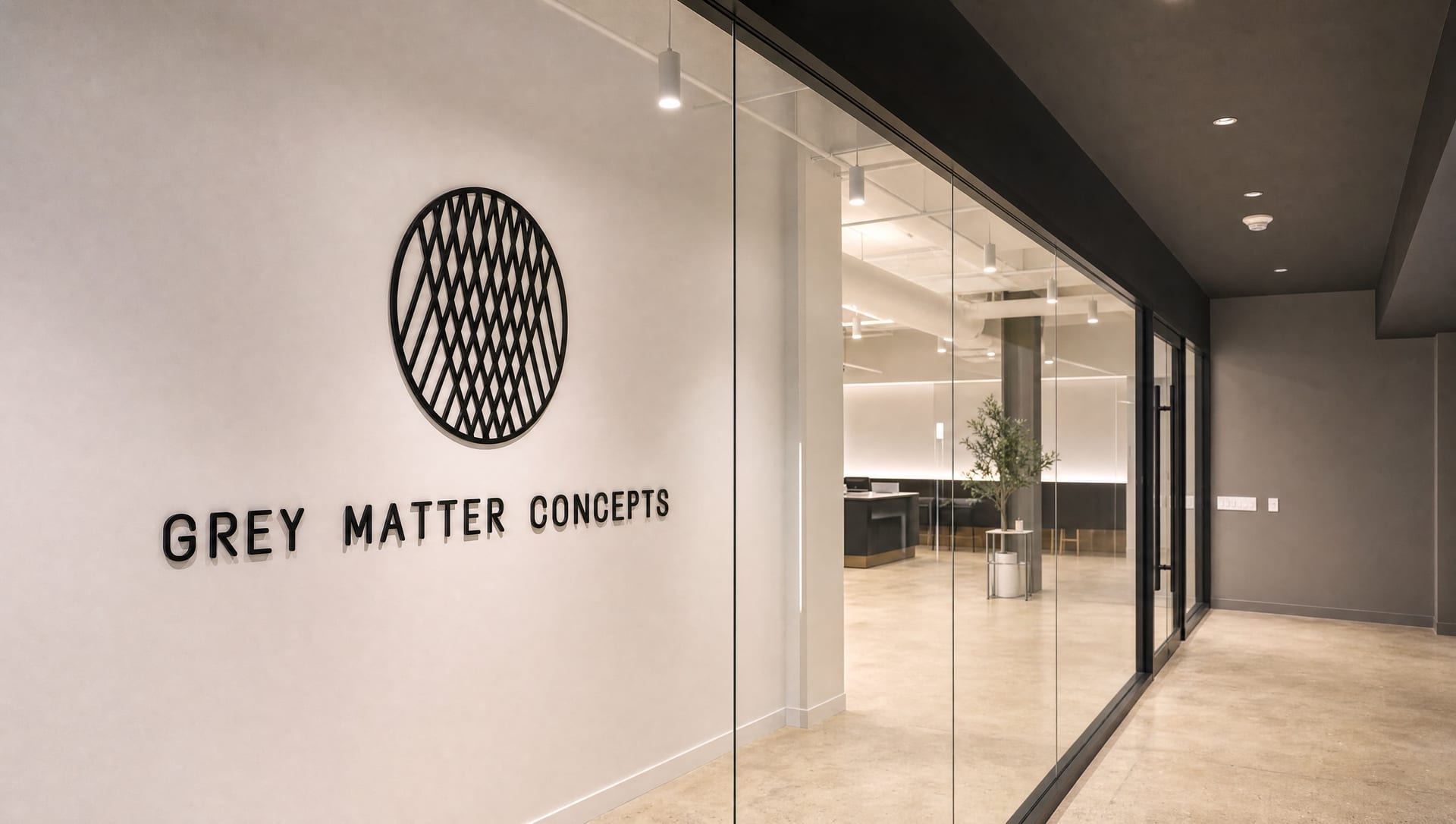 The Grey Matter Concepts wall signage in the New York office, with the glass-walled workspace beyond